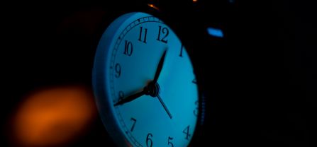 Stop the clock? – Verantwortung kennt keine Anwendungsschwellenwerte Ein analoger Wecker mit dunklem Hintergrund